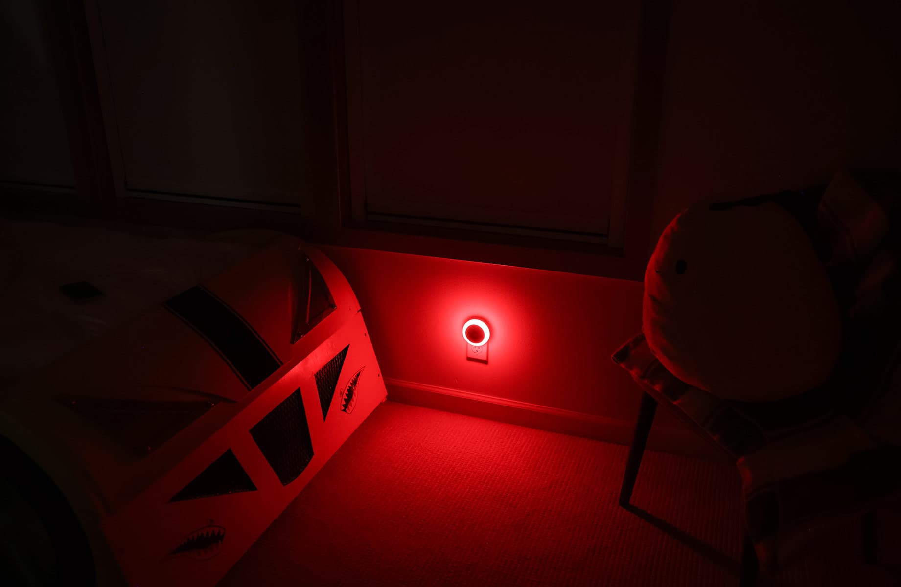 Darkened child's bedroom lit only by a red motion-sensor night light